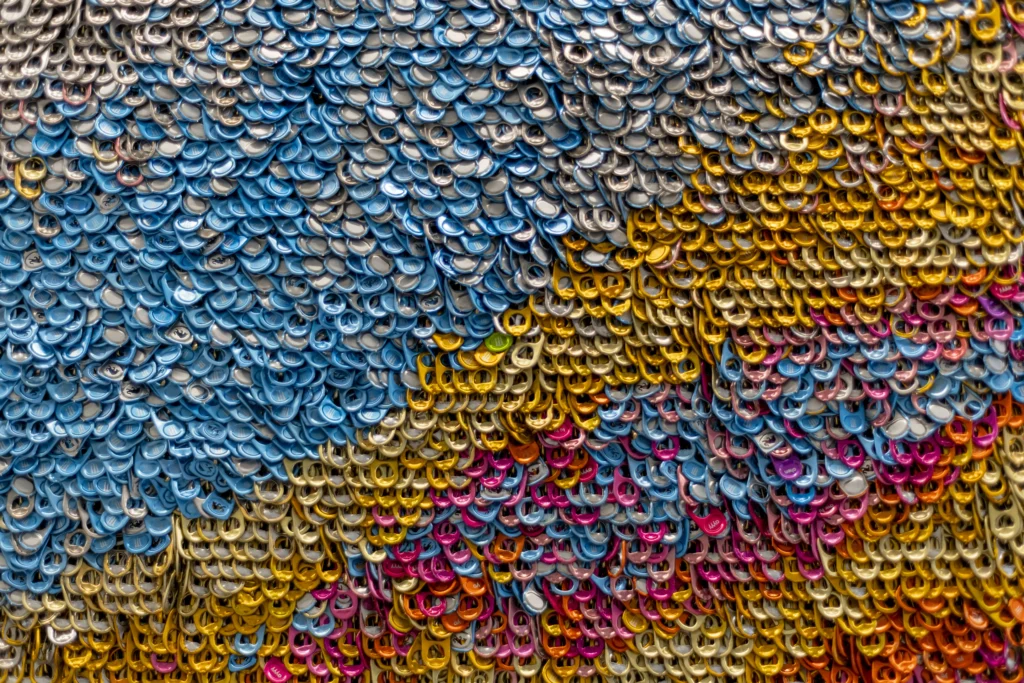 11-TIAA-Art-Package-Portfolio Detail of office art made with different colored soda can tabs.
