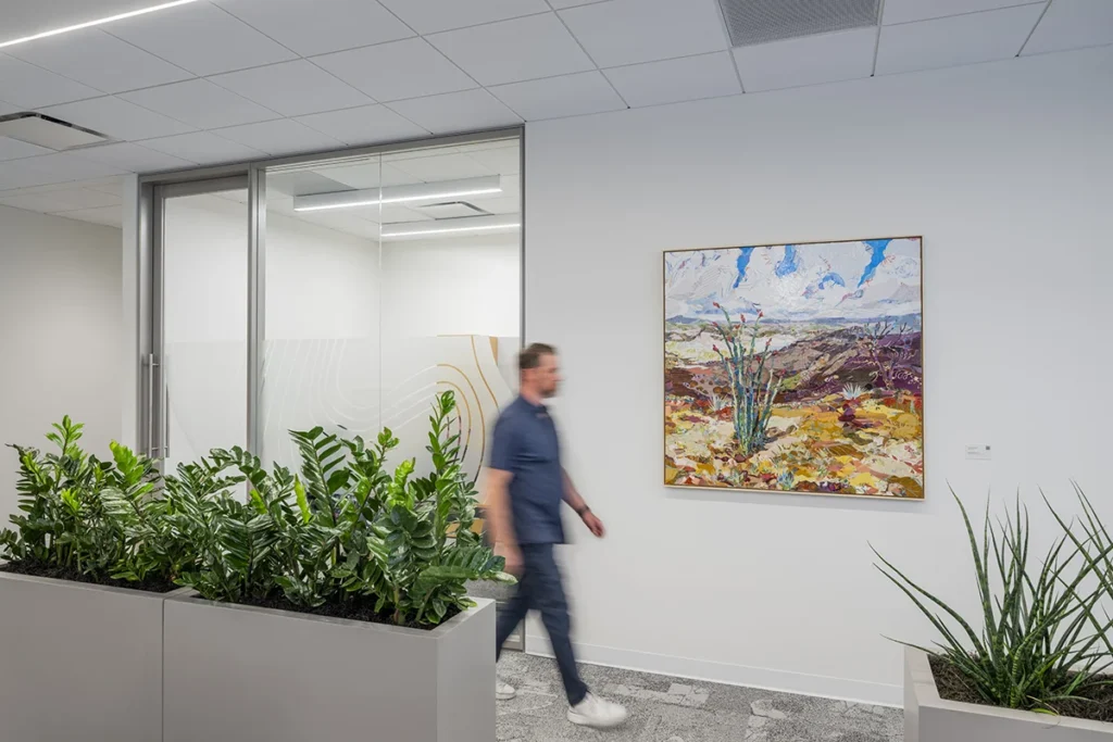 19-TIAA-Art-Package-Portfolio Man walks by art in office.