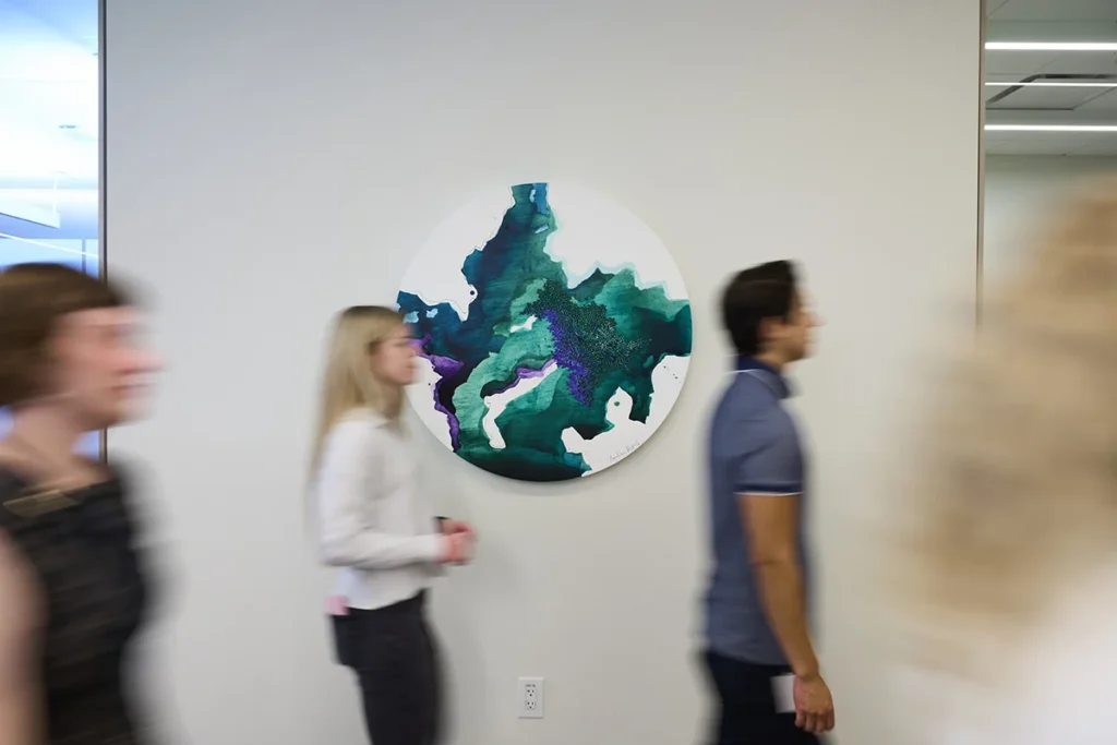 20-TIAA-Art-Package-Portfolio A group of people walk by art in the office.