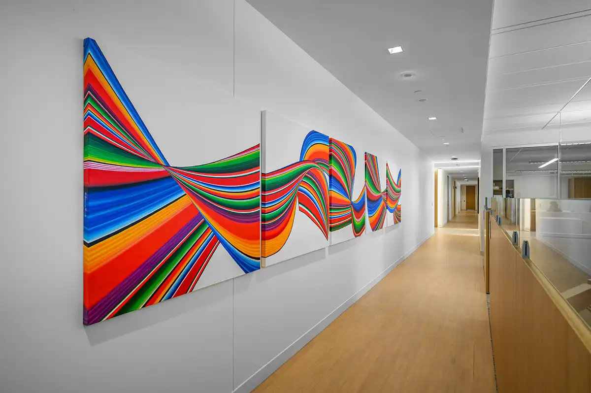 A painting with bold colors of a Mexican sarape design at the new CHRISTUS headquarters. Art consulting by Art + Artisans.