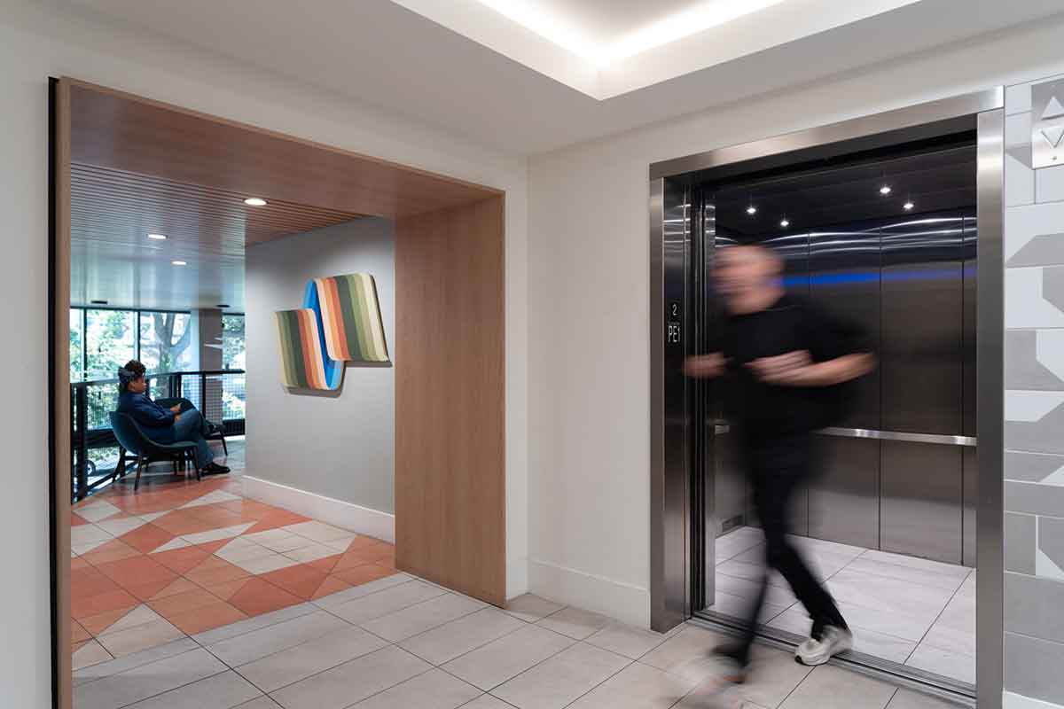 Bold abstract artwork with dynamic brushstrokes hangs in the corridor of a luxury student apartment building.