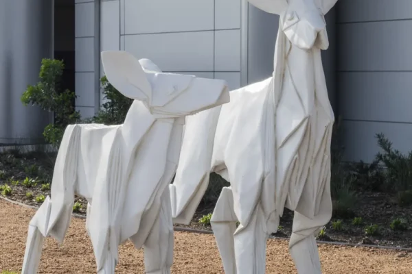Sculpture of two origami deer outside corporate office.