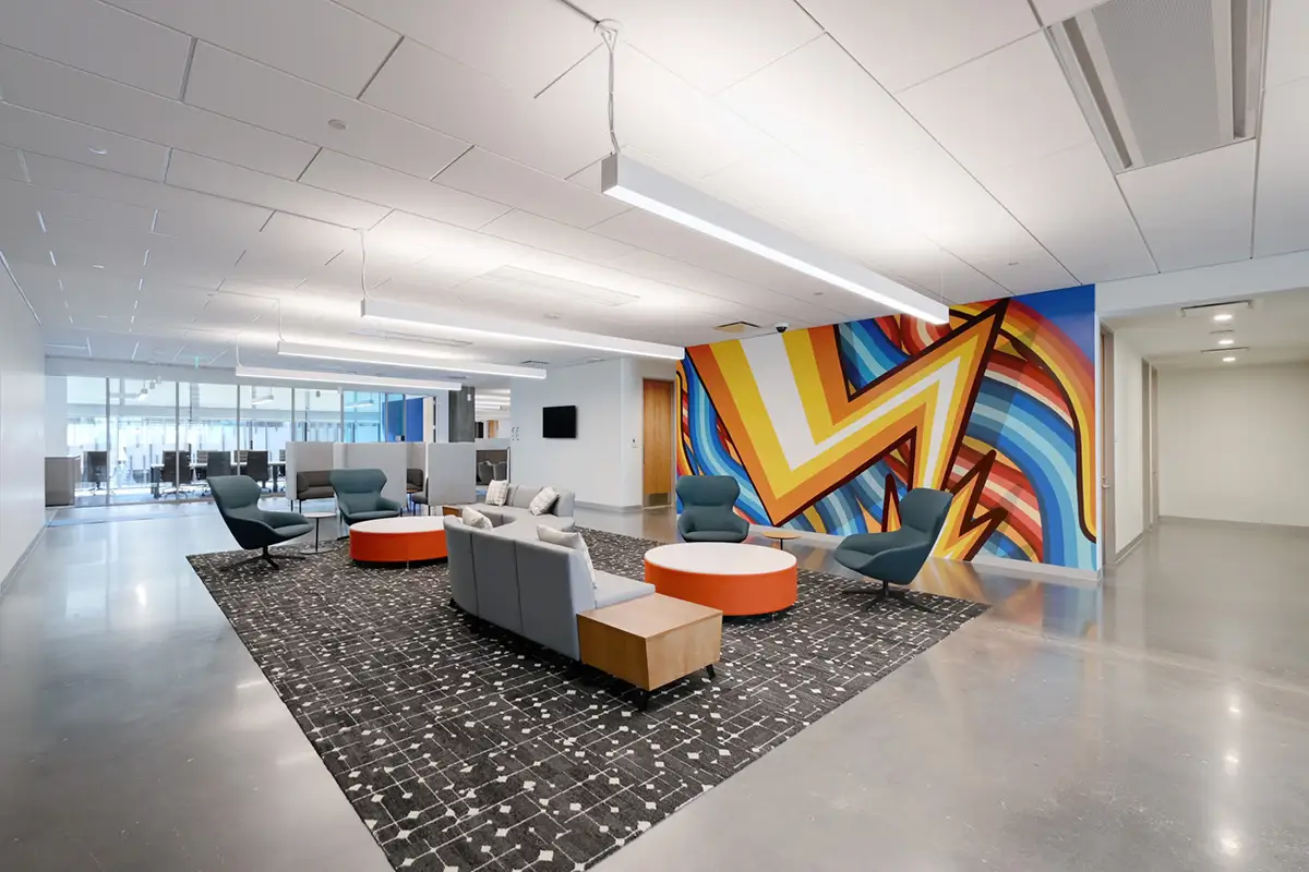 Interior office mural of a lightning bolt and colorful wires in a lobby seating area.