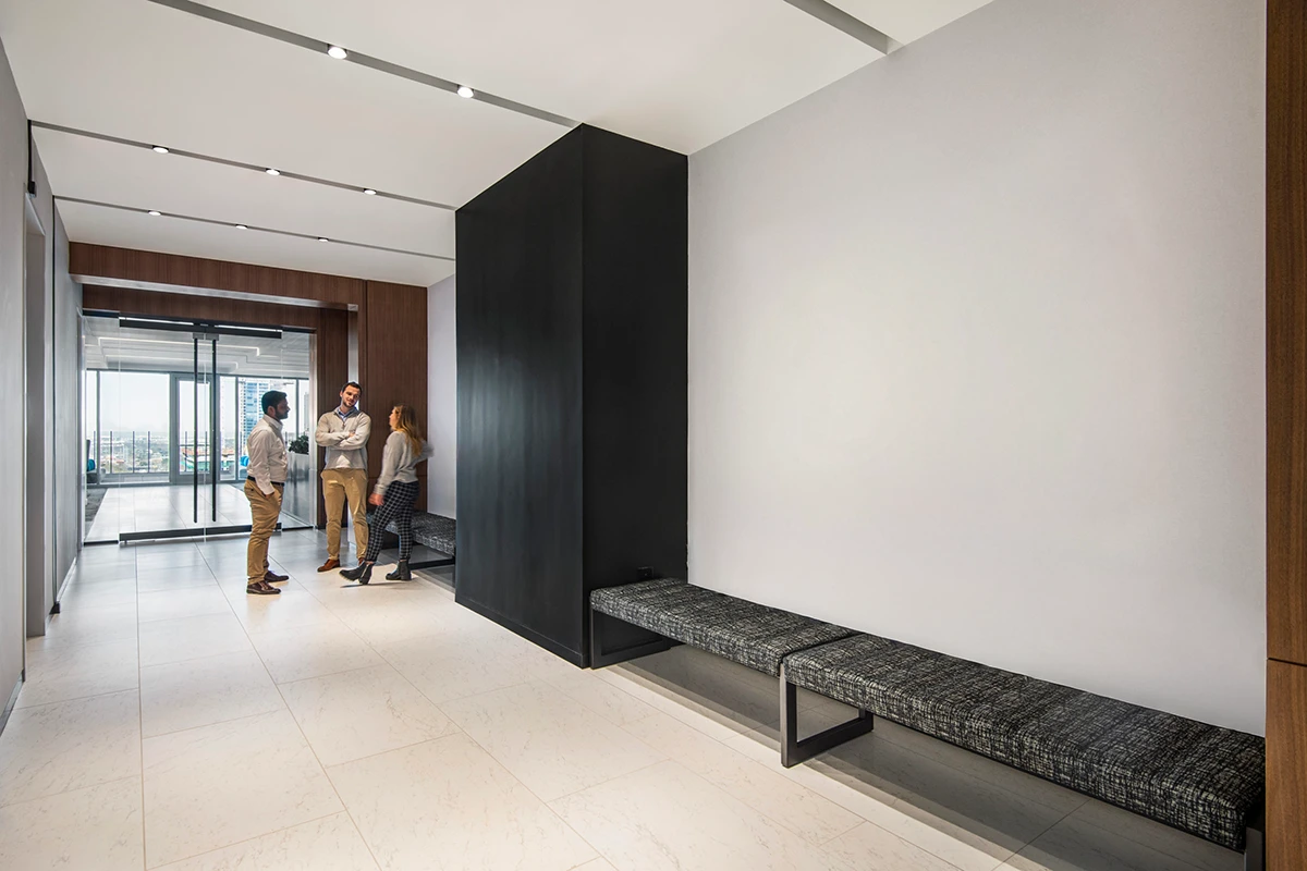 Grey office hallway with bare walls. No art.