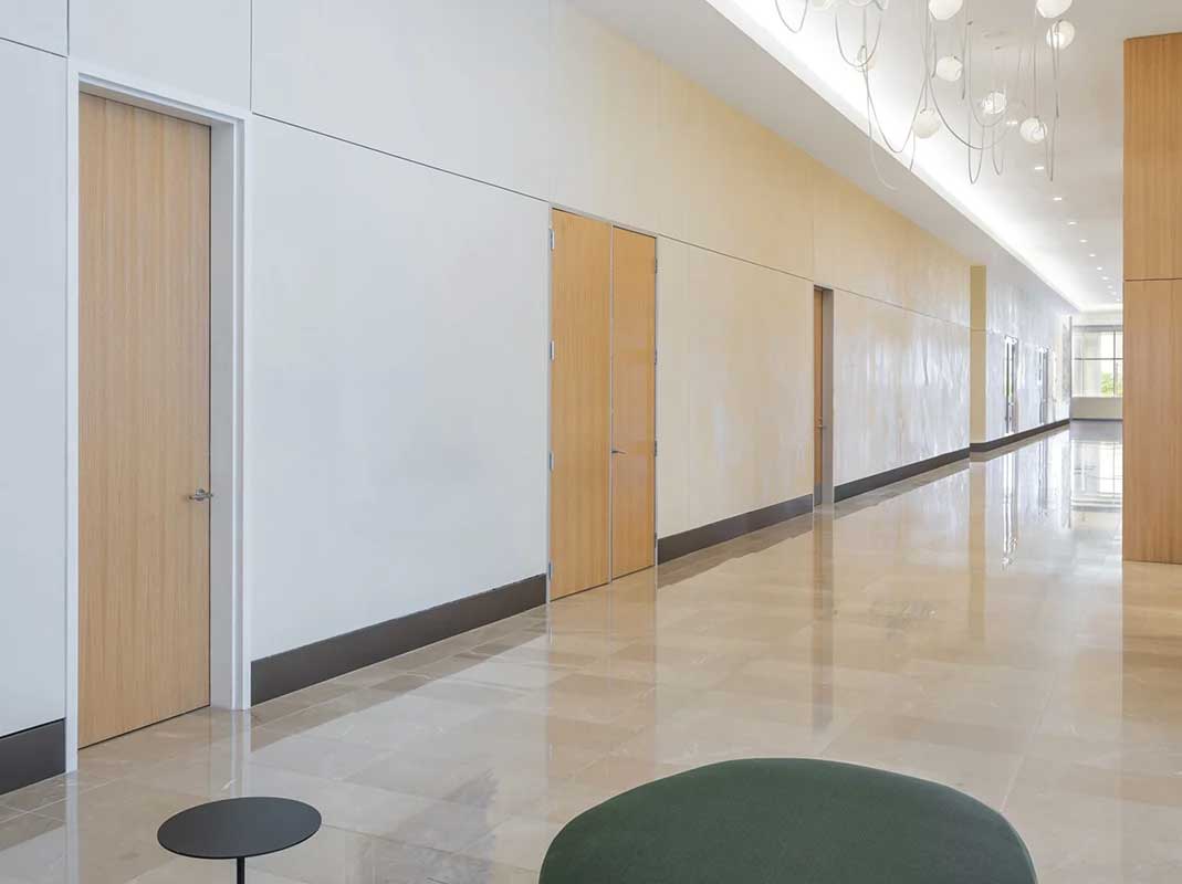 A cream and ecru office corridor with no art on the wall.