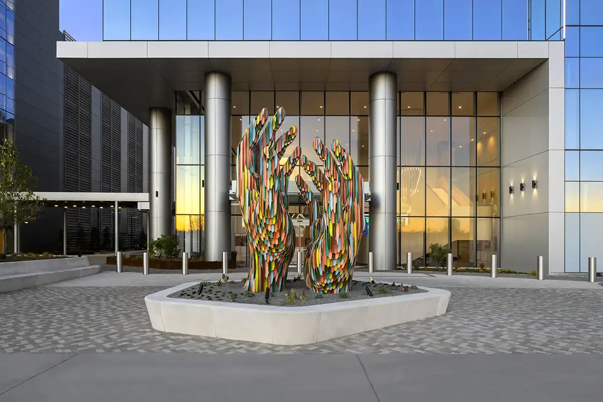 A massive sculpture of a pair of hands made of "colored pencils" in front of TIAA's Frisco tower represents the company's client base of educators and non-profit workers. 